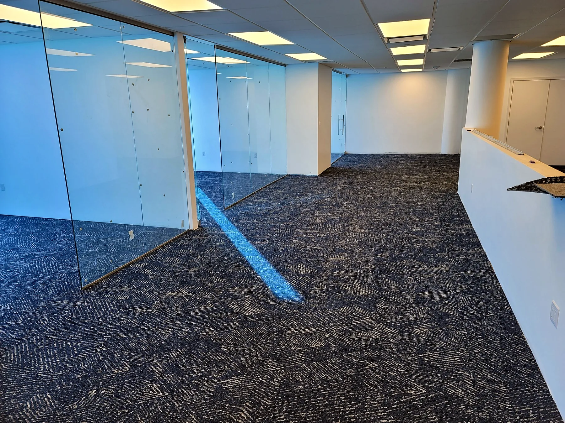 Patterned navy carpet tile meeting glass partitions