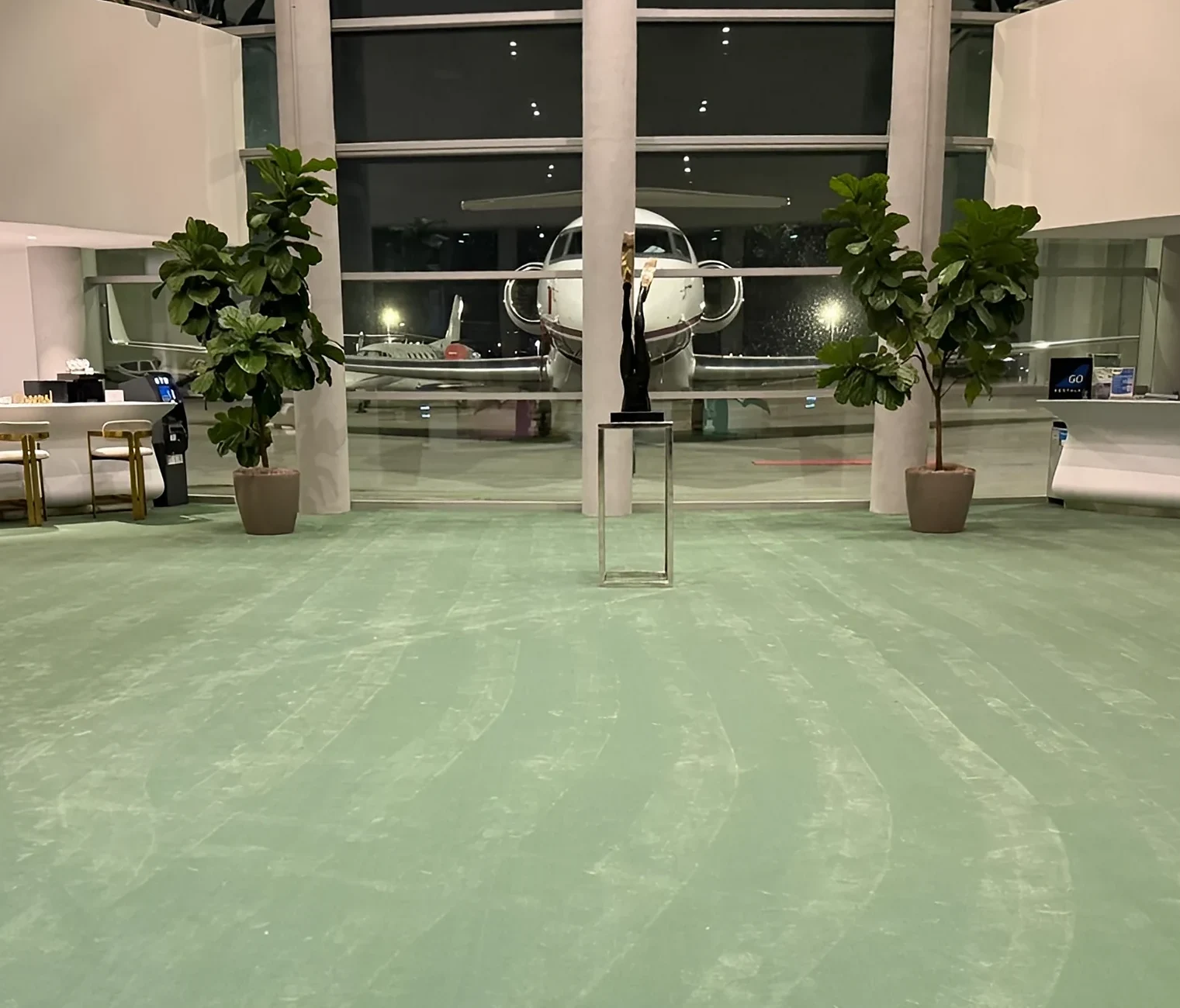 New green broadloom in a private aviation terminal lobby at night