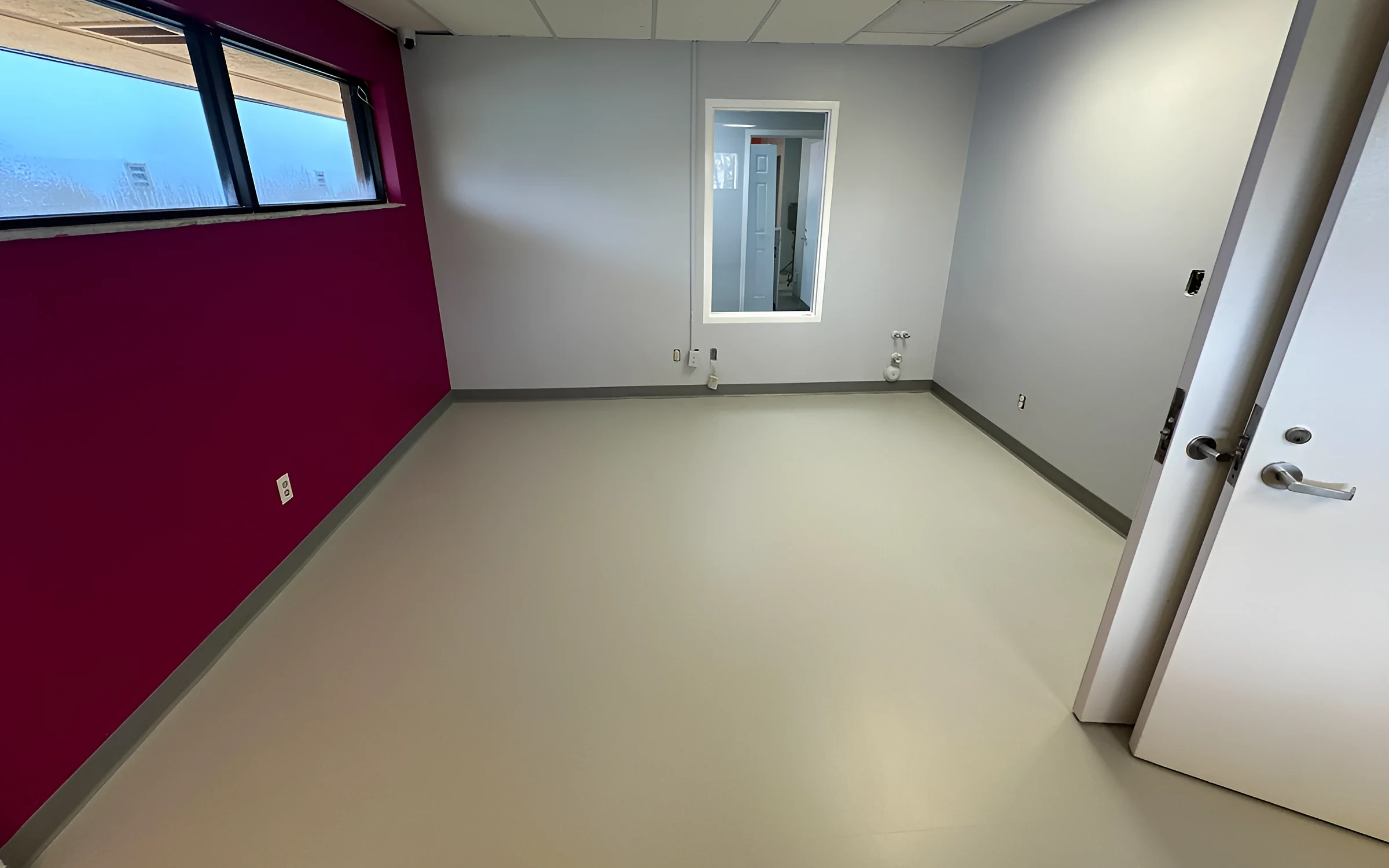 Club room with rubber tile and a magenta accent wall