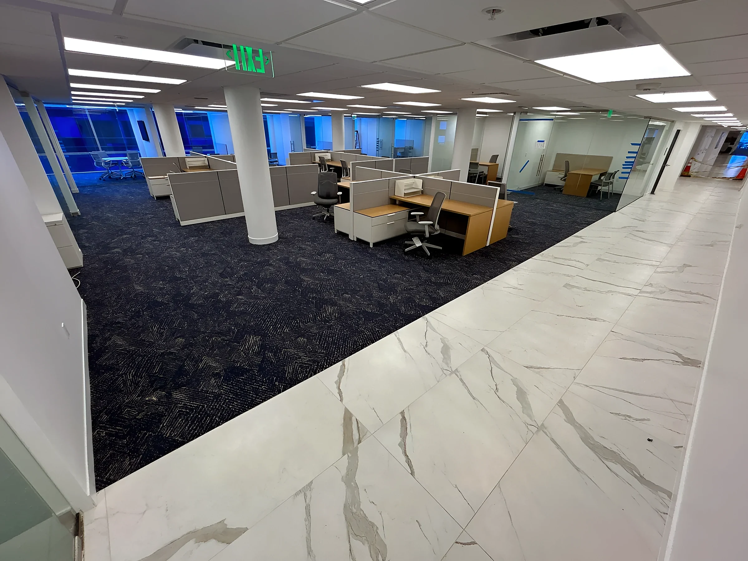 Ocean Bank headquarters open office with navy carpet tile and a marble-look tile path