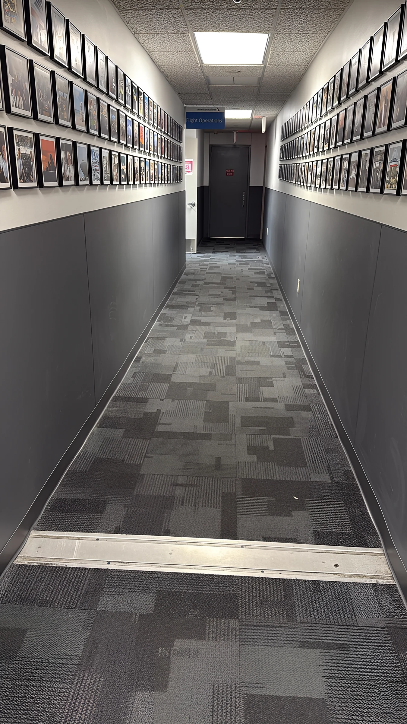 Pasillo de la sala de tripulación con loseta de alfombra y protección de paredes