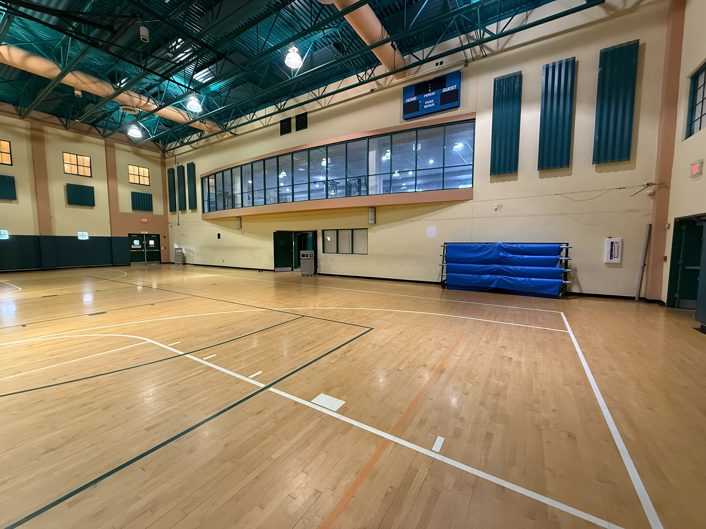 The refinished floor beside the viewing gallery and rolled gym mats