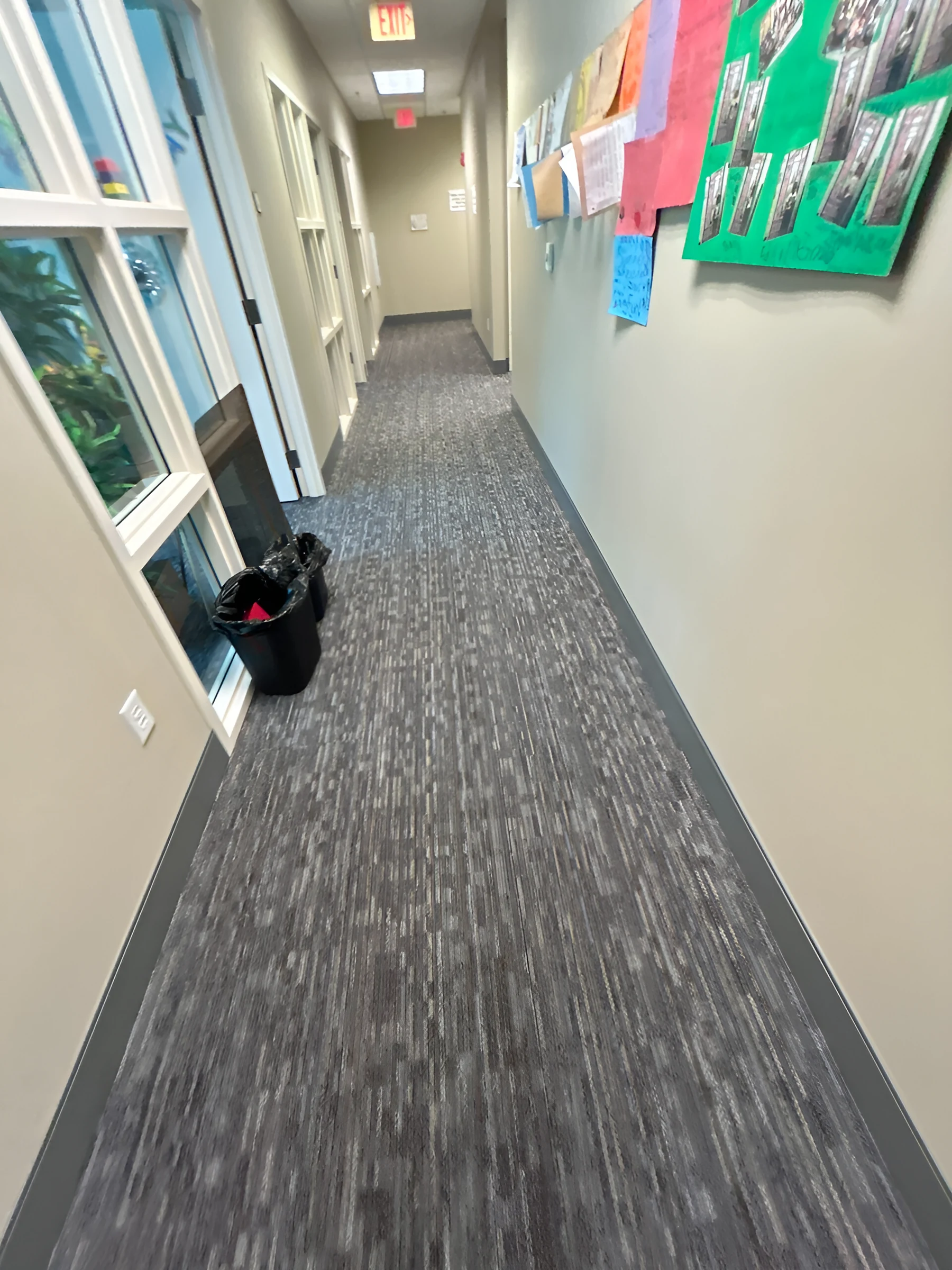 Un pasillo de oficinas terminado en tablón de alfombra