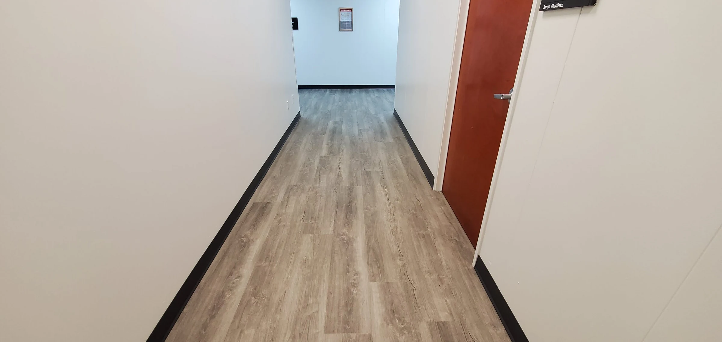 Un pasillo con paredes azules y el piso nuevo