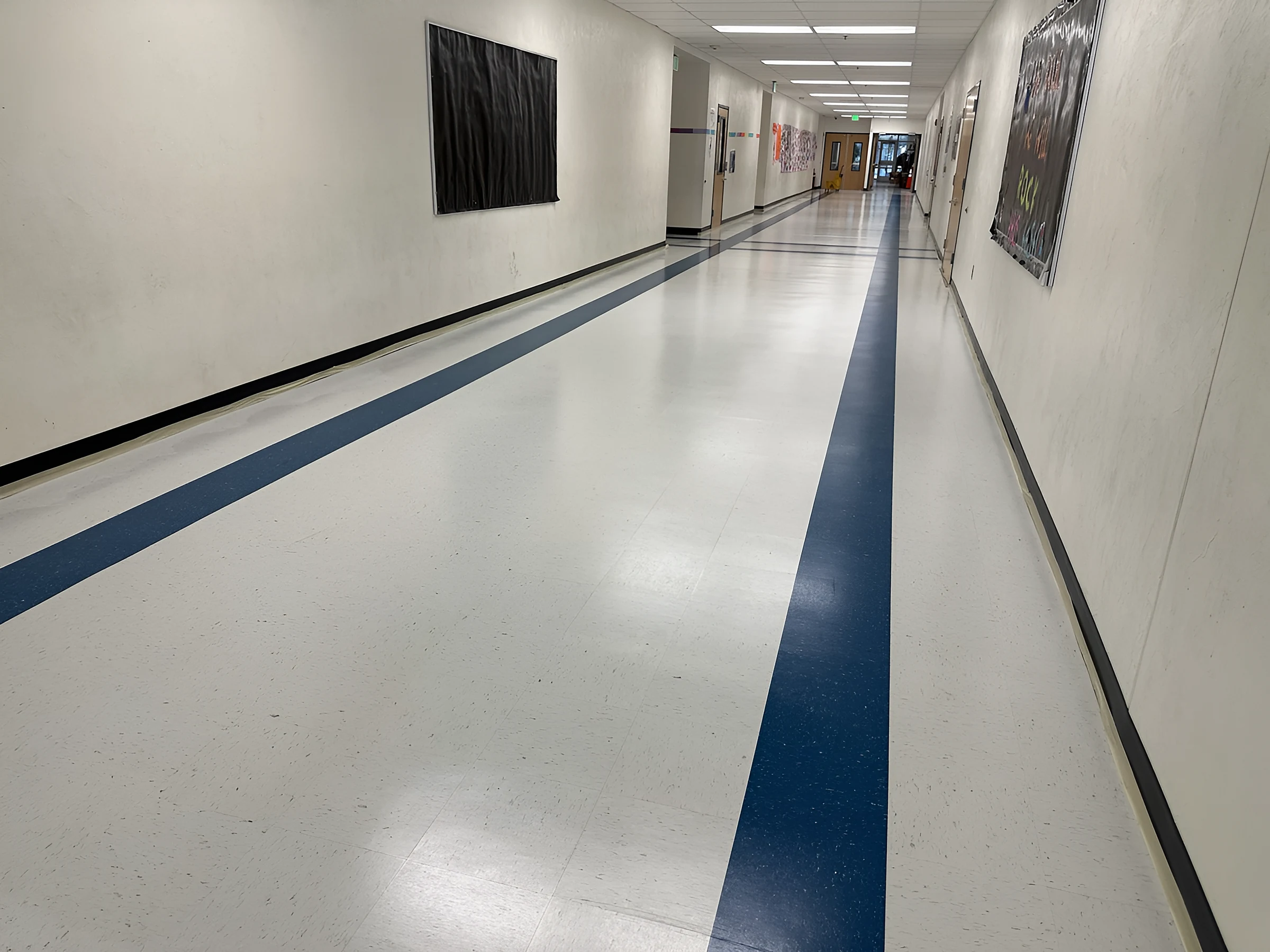 A blue band leading past classroom doors