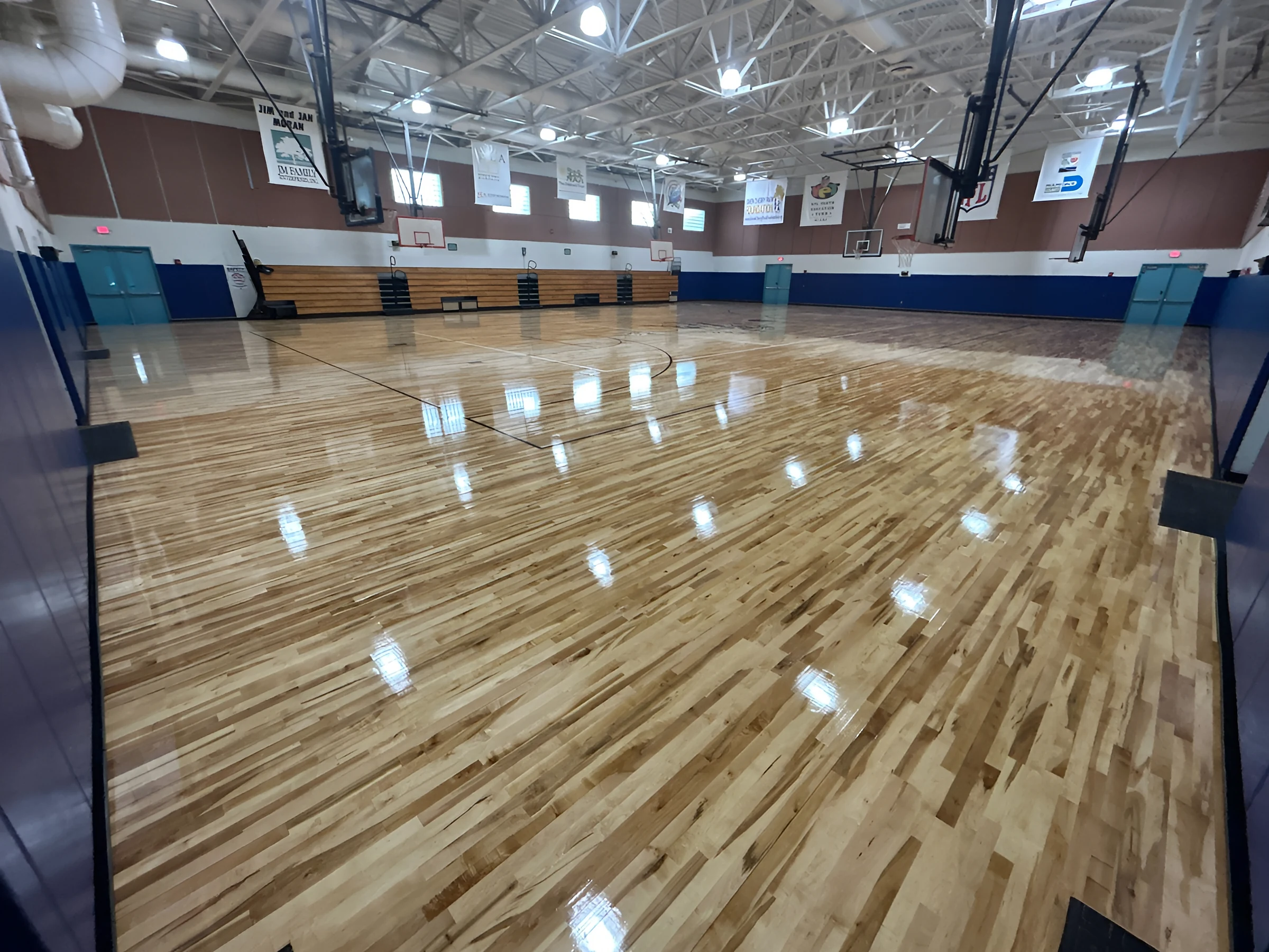 The sealed court catching the gym lights from end to end