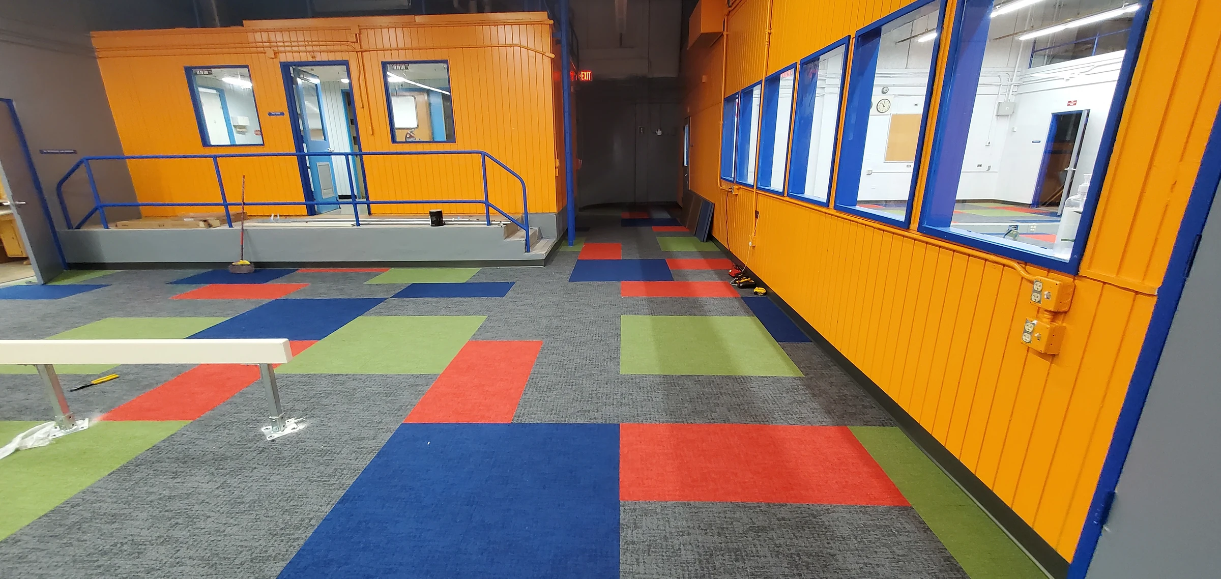 El mosaico junto a una pared naranja con ventanas de oficina