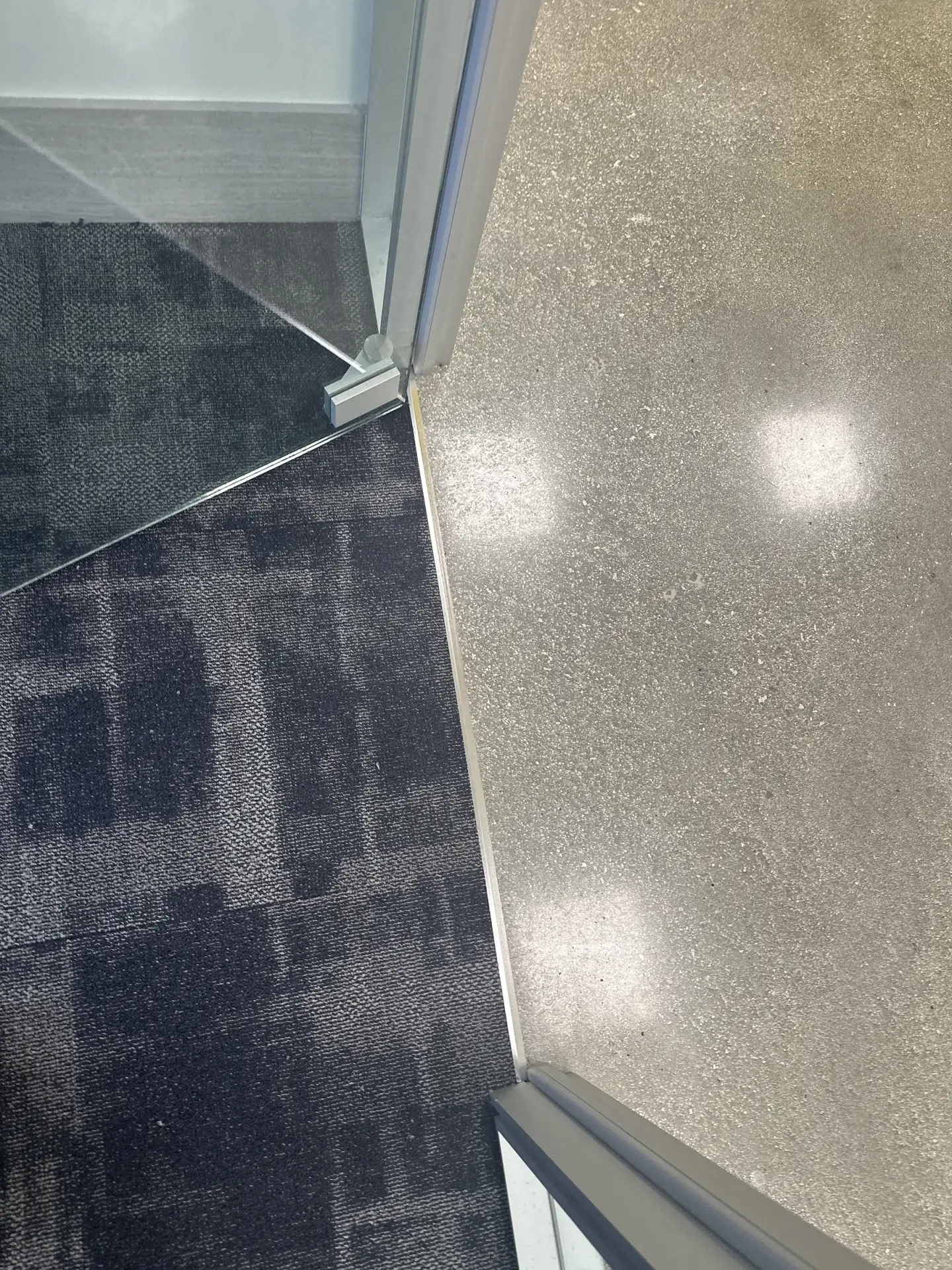 La alfombra junto a la piedra pulida en una pared de vidrio