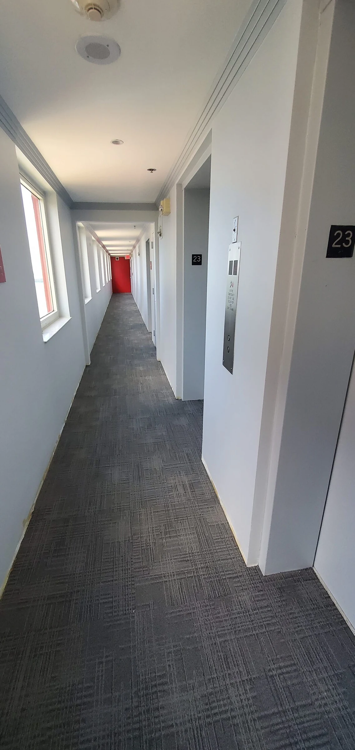 Pasillo residencial con alfombra gris