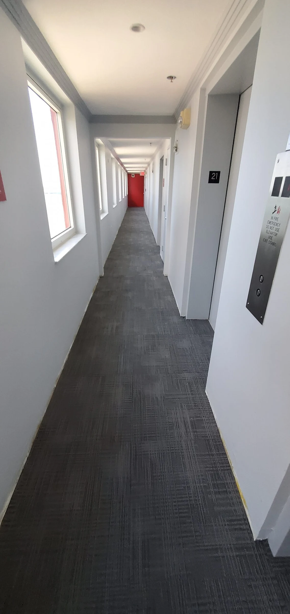 Un pasillo con la alfombra nueva y paredes blancas