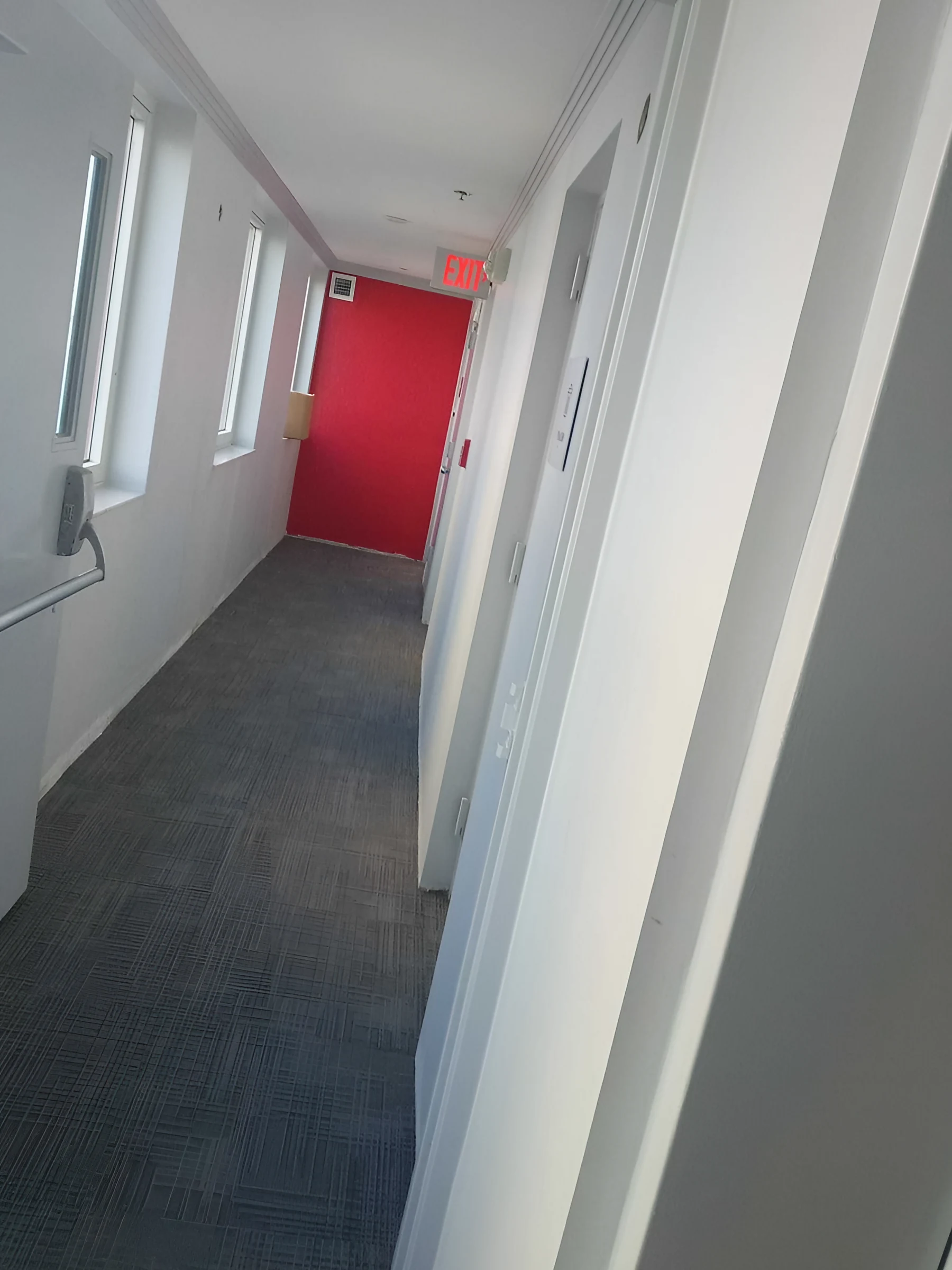 El pasillo que conduce a una puerta roja de acento