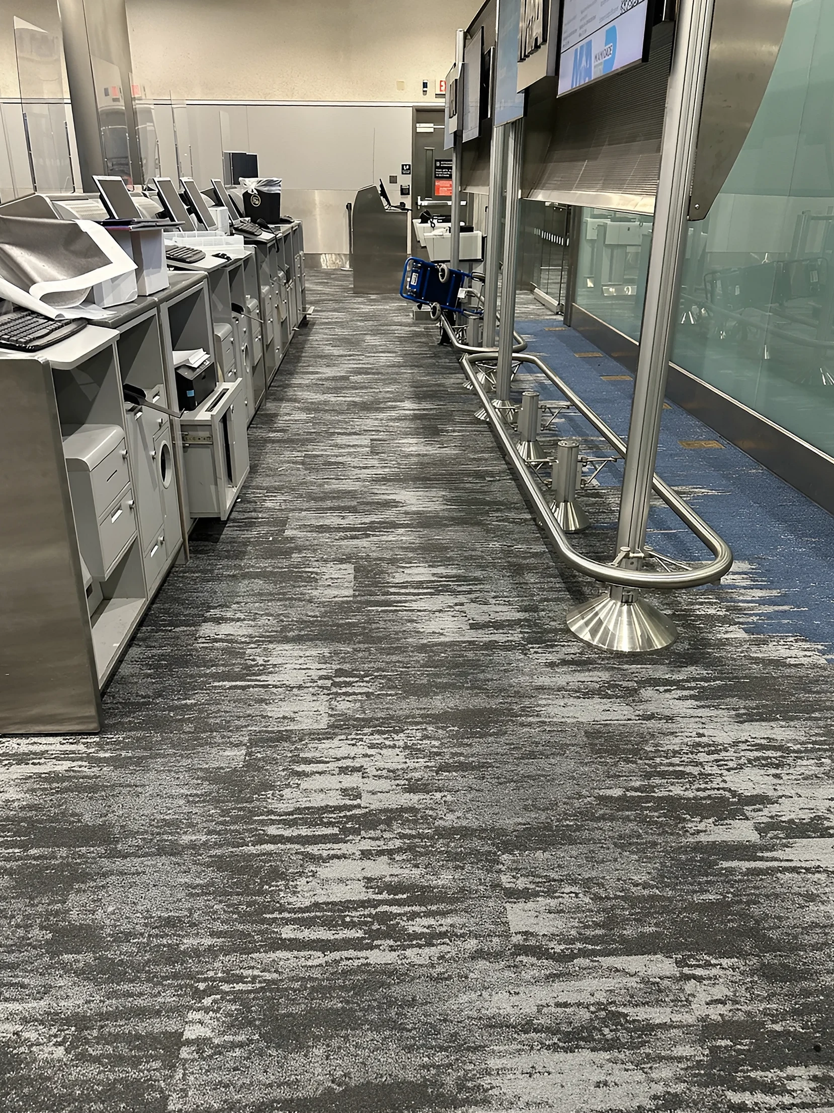 A band of blue running along the check-in kiosks and queue rail
