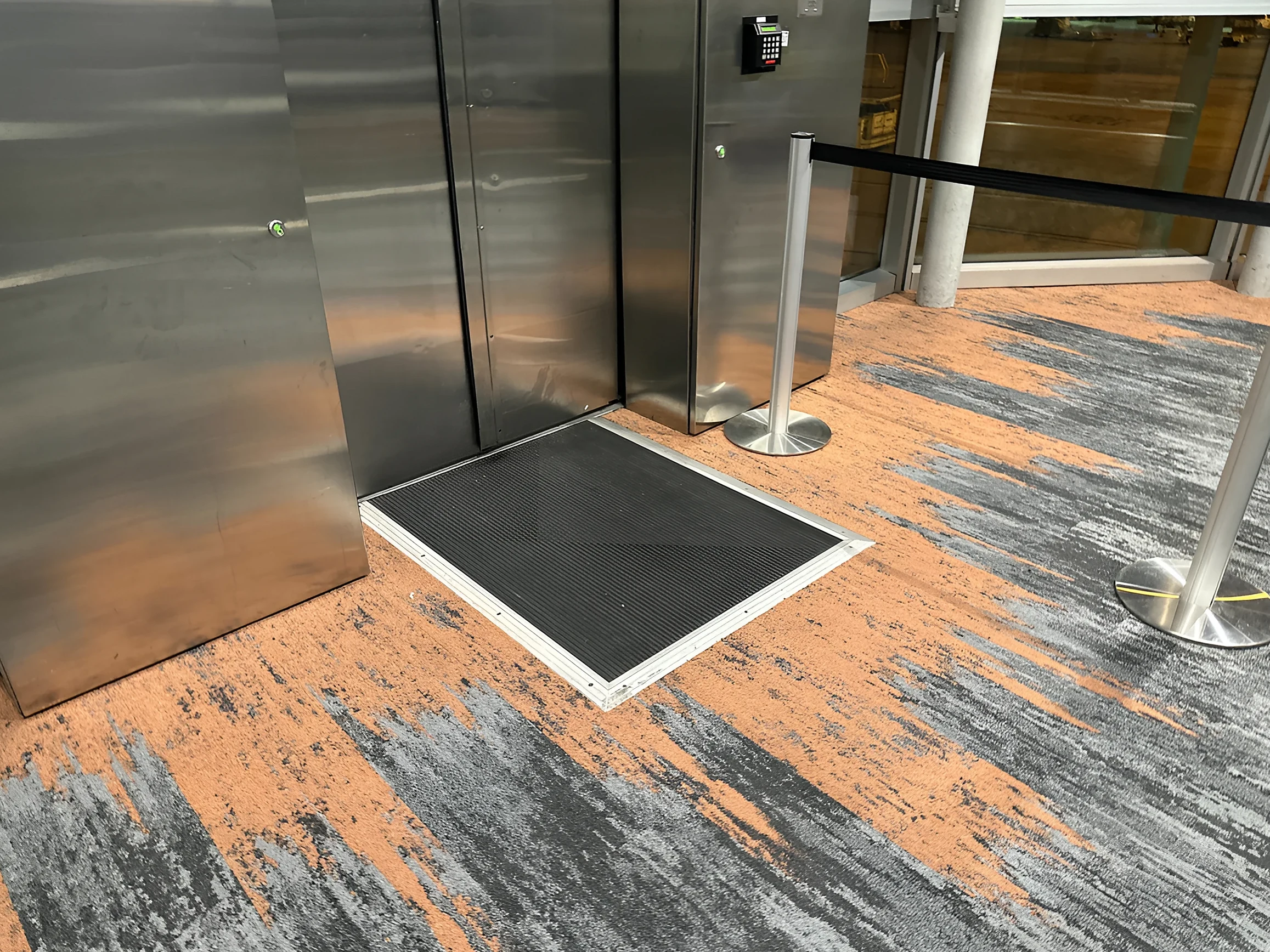 Coral accent at an elevator landing in the concourse