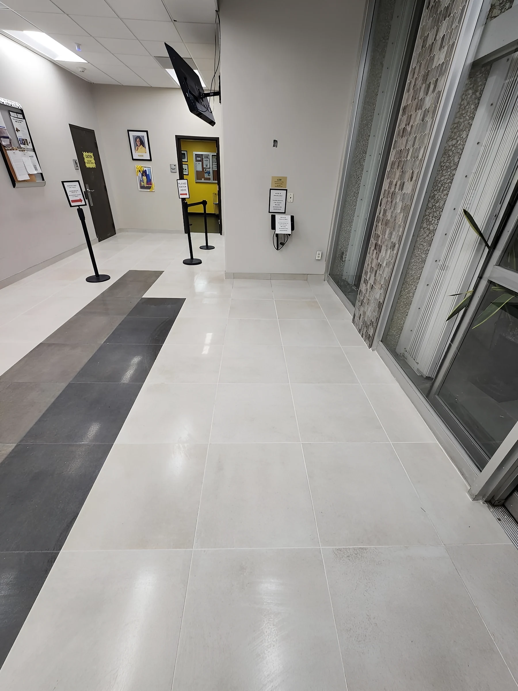 Franjas de porcelanato oscuro que guían a través del vestíbulo