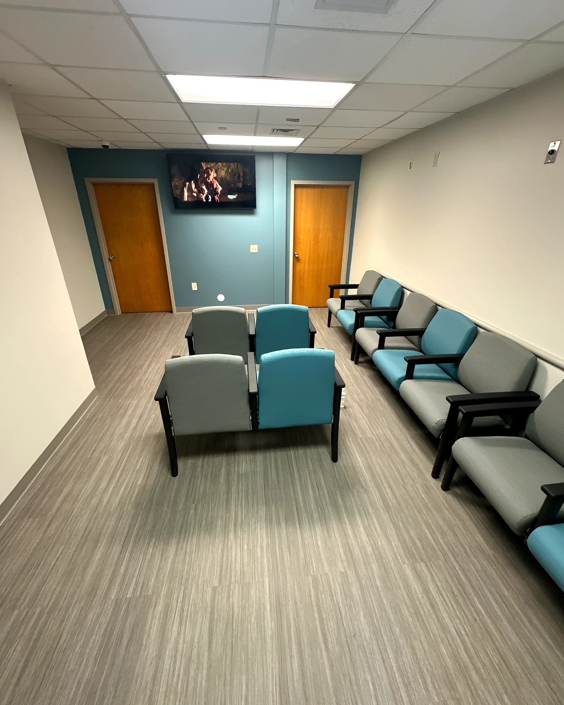 The clinic waiting area with wood-look LVT and a blue accent wall