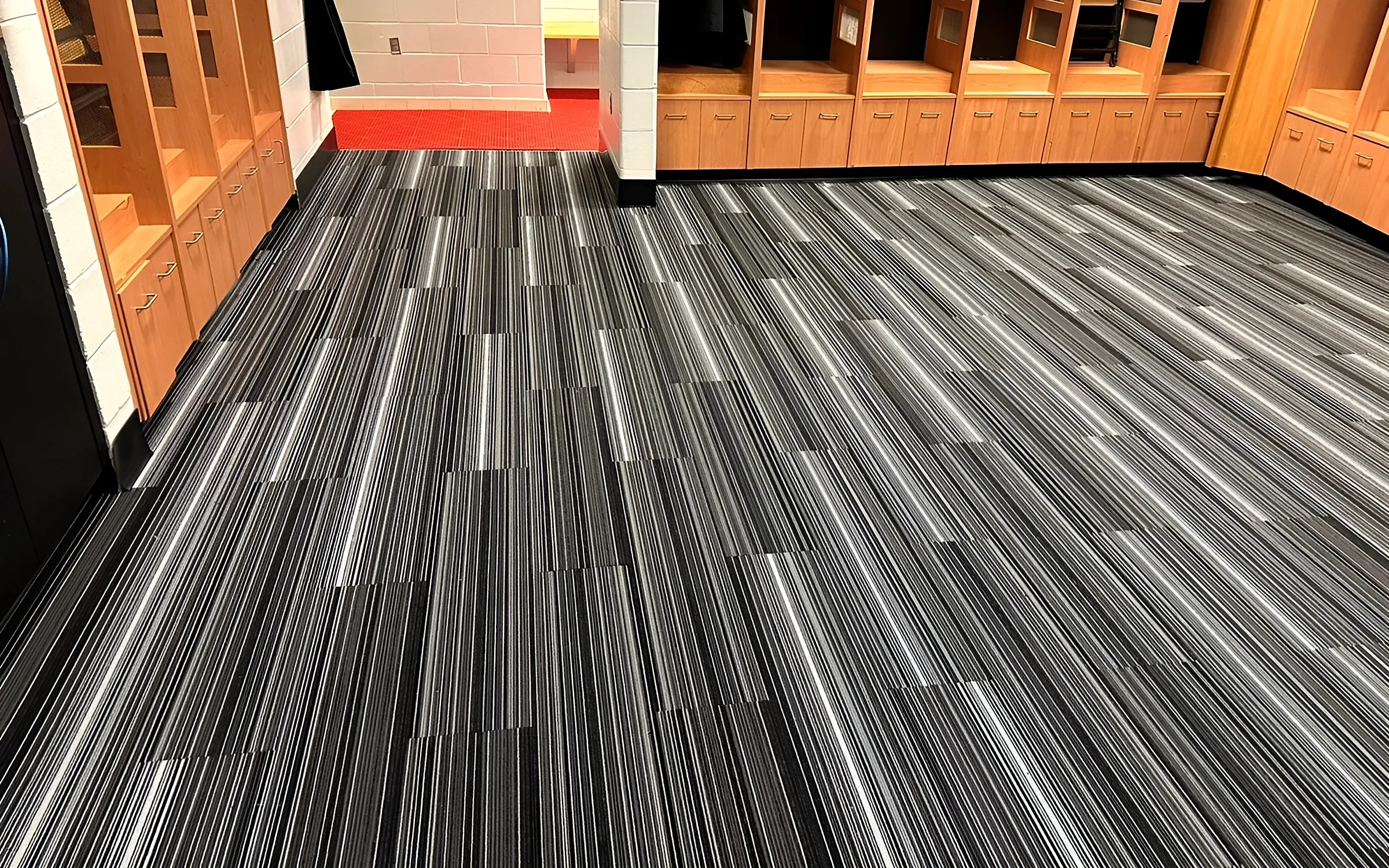 Florida Panthers locker room with striped carpet tile and wood lockers