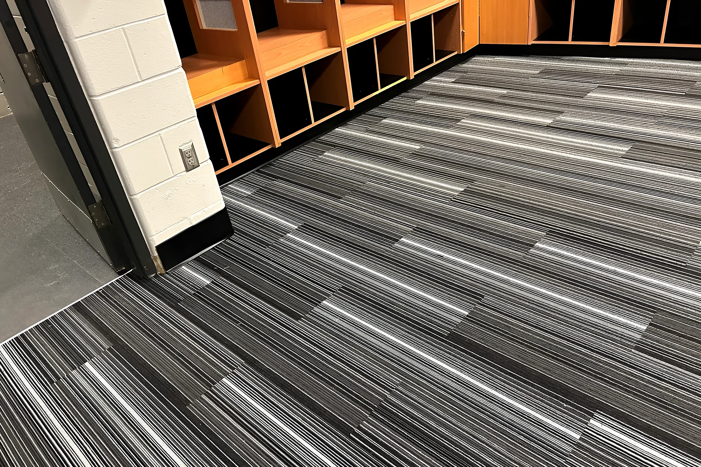 Striped carpet tile running into the locker bays