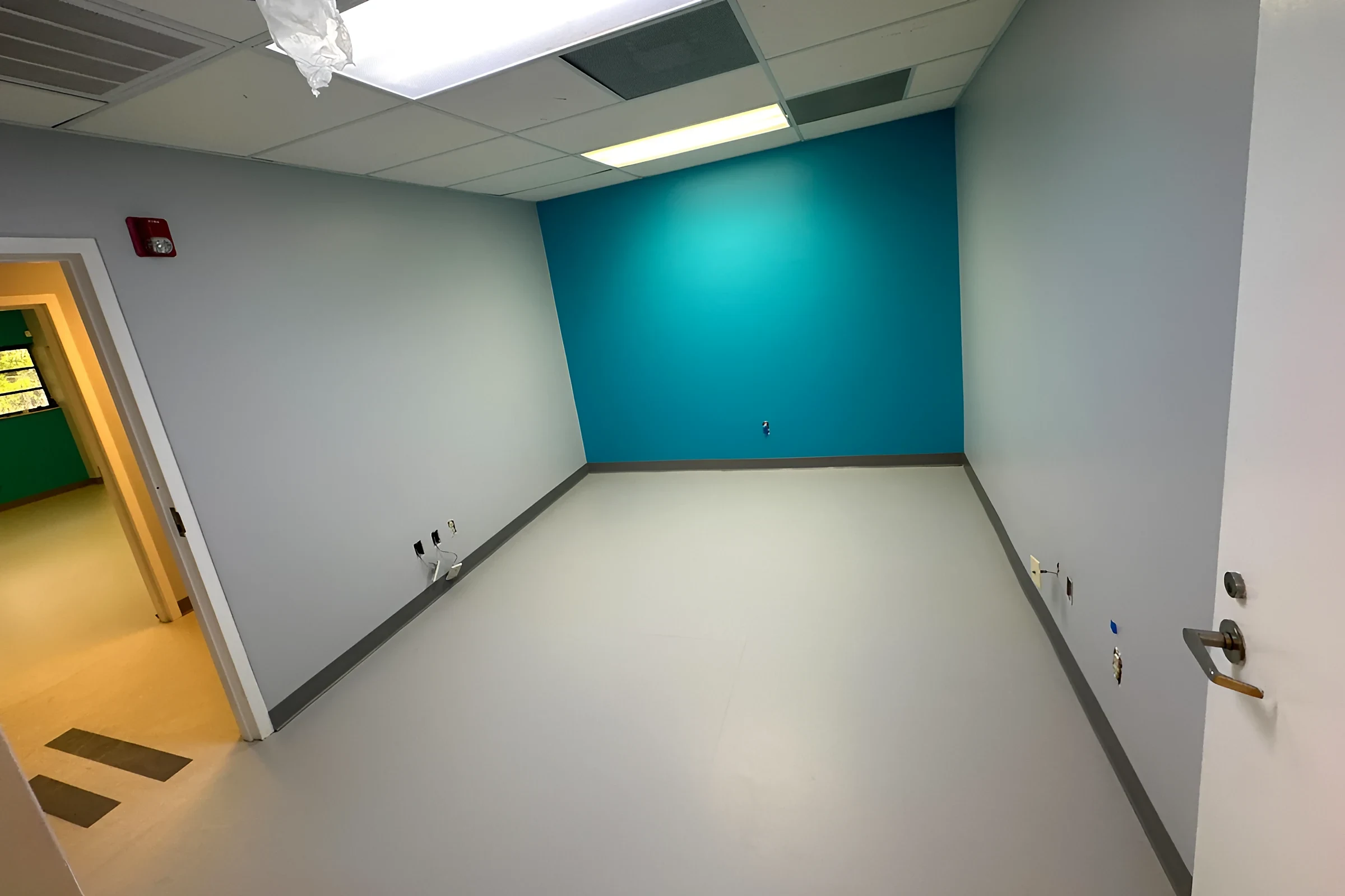 Club room with nora rubber tile and a teal accent wall