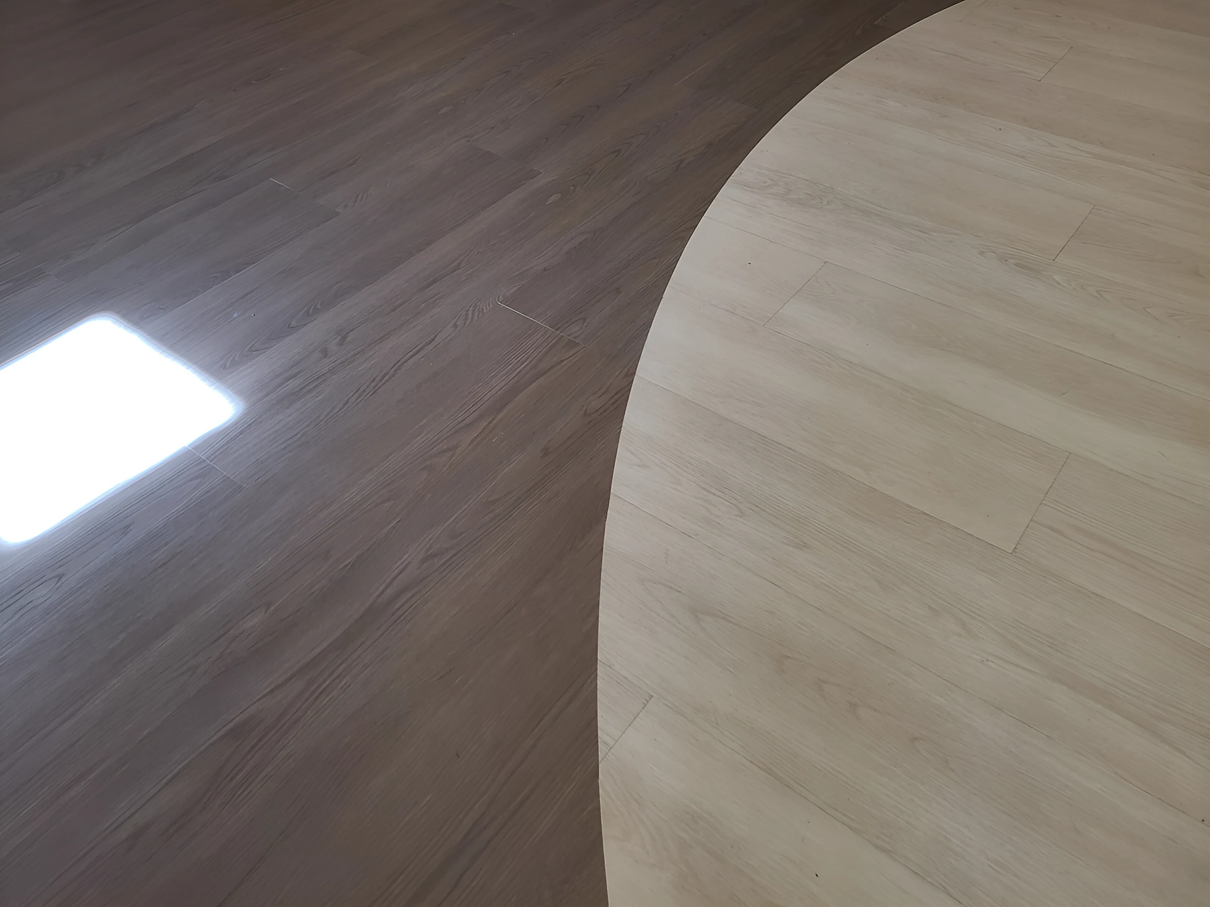 Light inlaid circle meeting the darker plank field in the lobby
