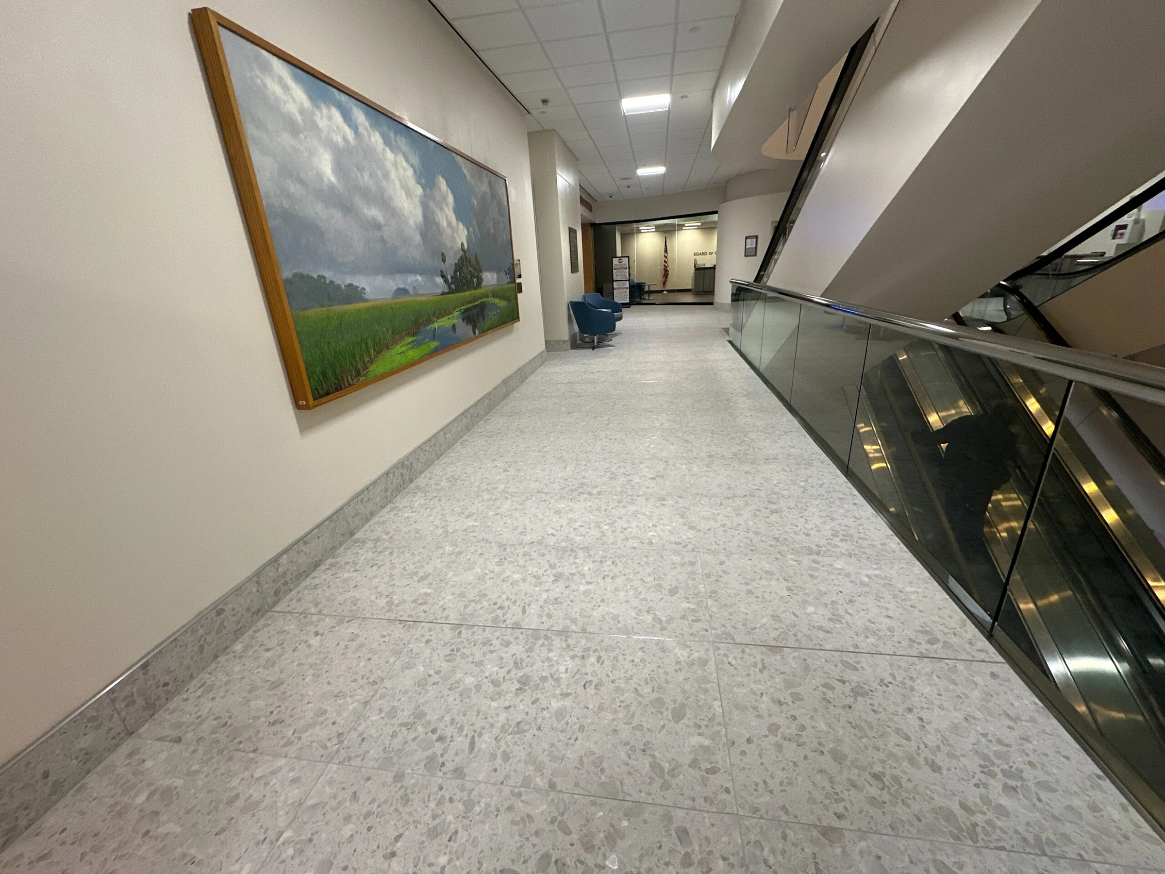 A lobby walkway lined with artwork beside the escalators