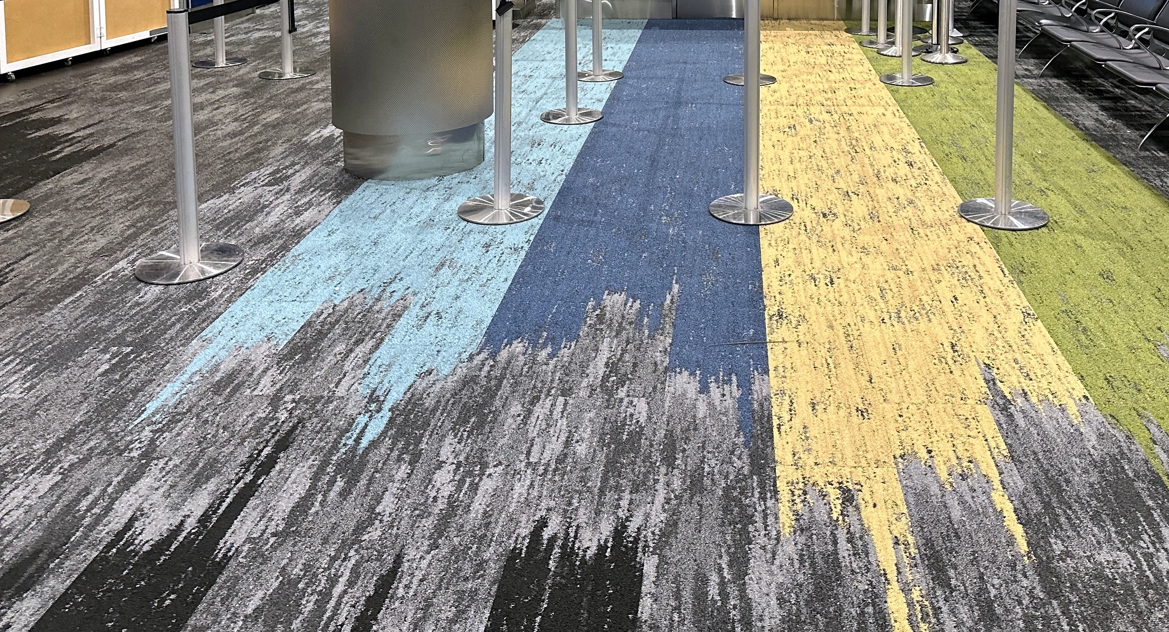Queue lanes in sky blue, deep blue, yellow and green at a Concourse J gate